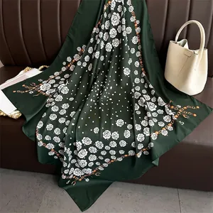 Detailed pattern of dark green silk scarf with white roses, dots and gold chain motifs