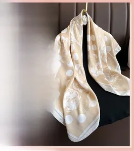 Detailed pattern of floral and polka dot silk scarf hanging on gold flower hook