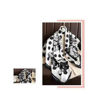 Detail of silk satin scarf with black and white polka dots and floral pattern prints