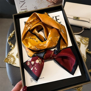 Detail of elegant floral satin scarf featuring yellow and burgundy contrast colors