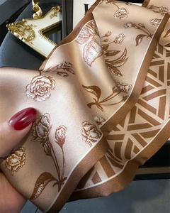 Macro detail of silk scarf showing rose floral prints and elegant satin texture