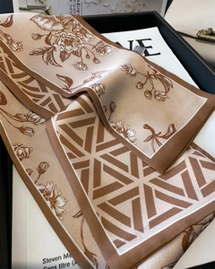 Detail of silk-like floral scarf texture and printed pattern on a black tray