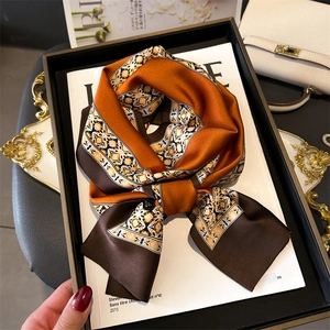 Detailed view of luxury floral print silk scarf with vintage patterns on a magazine