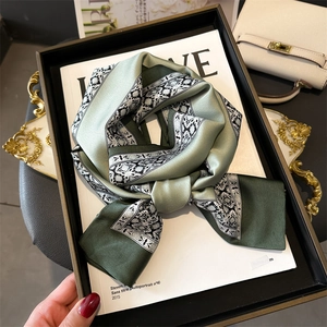 Close-up of floral print silk scarf tied elegantly on a decorative magazine tray