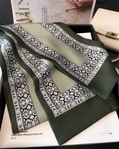 Detail of elegant dark green silk scarf with vintage floral print in a gift box