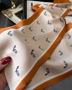 Close-up of elegant floral silk scarf featuring a horse head print and contrasting border