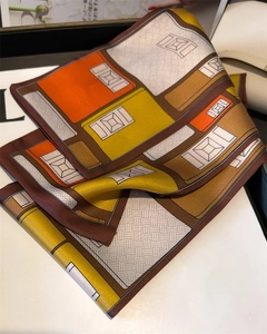 Détail d'une écharpe longue en soie avec imprimé géométrique moderne et blocs de couleur