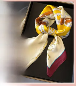 Detailed view of luxury satin square scarf with chain motifs in gold and red