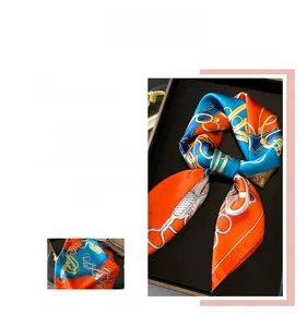 Detail of silk scarf with orange and blue chain print and elegant knot texture