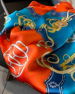 Detailed close-up of a satin silk scarf featuring vintage chain and harness patterns