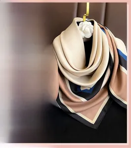 Détail d'un foulard en soie aux motifs géométriques color-block sur un fond en cuir luxueux