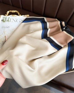 Détail du foulard de luxe en soie aux motifs géométriques et finitions de couture fines