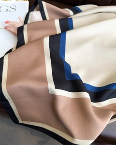 Détail d'un foulard en soie montrant des motifs géométriques et un tissu de luxe doux