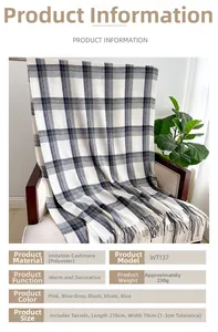 Detail of plaid imitation cashmere scarf with tassels draped over a wooden chair