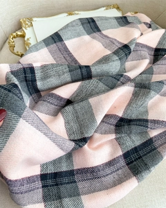 Close-up of soft pink and grey plaid scarf with woven texture and fringe details