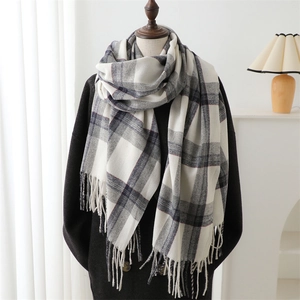 Plaid cashmere-like scarf with tassels styled on a black wool coat for a winter look