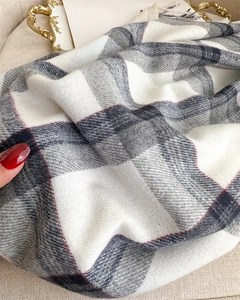 Close-up of soft grey and white plaid cashmere-like scarf with fringe and twill weave detail