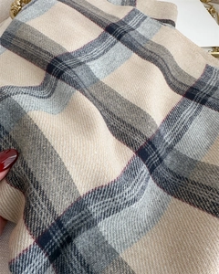 Macro shot of soft plaid cashmere scarf with twill weave texture and beige gray pattern