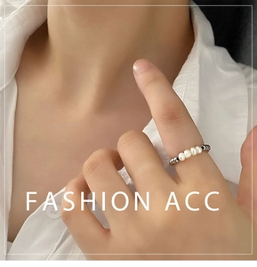 Detail of natural freshwater pearl beaded ring with metallic accents on hand