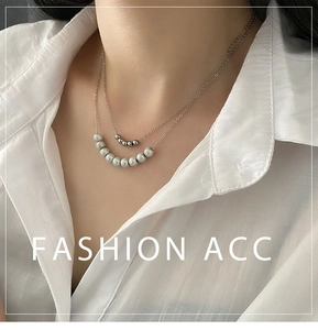 Detail of layered double strand necklace featuring silver beads and grey pearls on model