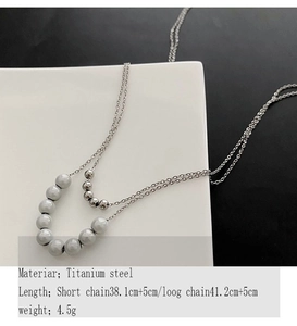 Detail view of double-layer titanium steel necklace with elegant grey beads and silver pearls