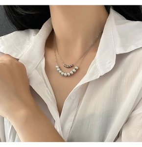 Detail of layered double strand necklace featuring grey pearls and silver metal beads