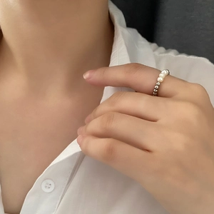 Elegant beaded ring featuring dainty freshwater pearls and polished metal beads on finger