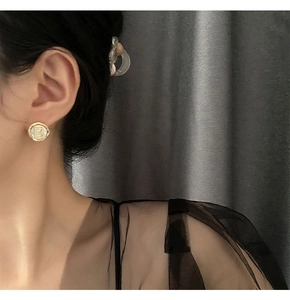 Close-up of vintage gold-plated B-letter stud earrings with twisted rope texture edge