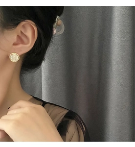 Close-up of elegant gold stud earring featuring mother of pearl inlay and letter B design