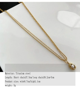 Détail d'un collier double rang en acier titane doré avec pendentif perle en forme de pois