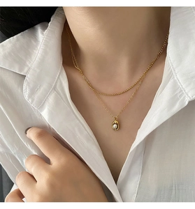 Vue détaillée du collier double rang doré avec pendentif perle sur une chaîne raffinée