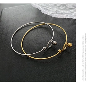 Detail of minimalist gold and silver bead closure bracelets on a stone texture background