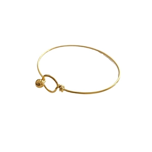 Minimalist gold titanium steel bangle with ball charm and polished finish
