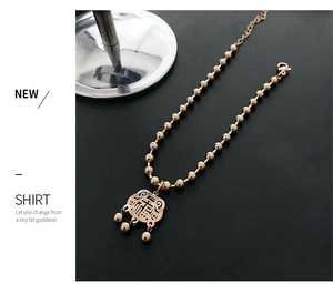 Detail of rose gold beaded bracelet with a traditional longevity lock pendant and bells