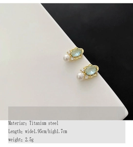 Detail of vintage titanium steel earrings with light blue stone and pearl accents