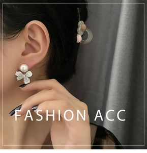 Close-up of elegant flower earrings with white pearls and sparkling diamond centers