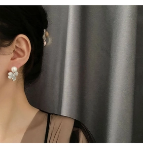 Elegant pearl flower stud earrings worn by model showing delicate floral design and shine