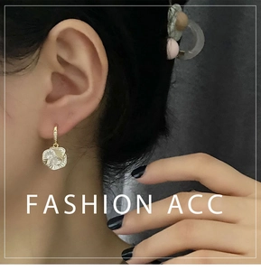 Close-up of camellia flower earrings with gold petals and white pearlescent inlay