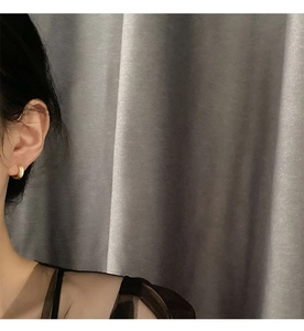Gros plan détaillé d'une boucle d'oreille créole dorée minimaliste à la finition polie