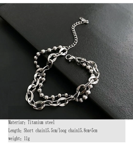 Dettaglio del bracciale a doppio strato in acciaio al titanio con catena cubana e moschettone