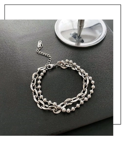 Dettaglio del bracciale a doppio strato in acciaio con catena cubana, sfere e chiusura a moschettone