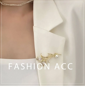 Détail d'une broche tulipe de luxe avec strass et perle sur le revers d'un tailleur blanc