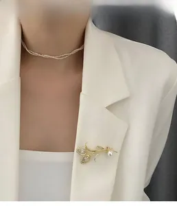 Détail d'une broche tulipe de luxe avec cristaux et perle sur un revers blanc