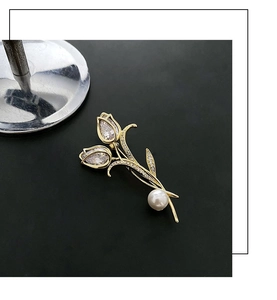 Détail macro de broche tulipe avec cristaux en poire et incrustation d'une perle blanche