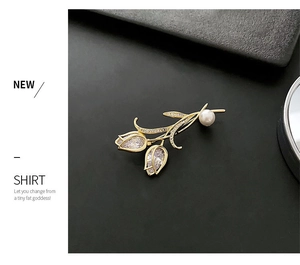 Détail macro d'une broche tulipe avec zircons, petits diamants et une perle blanche