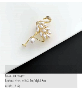 Macro shot of elegant golden flamingo brooch with pearls and white crystals, 2.7x4.8cm