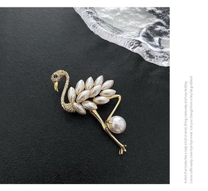 Close-up of flamingo brooch with white marquise pearls and zircon pavé on gold metal
