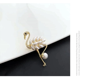 Detailed view of flamingo brooch with white pearls and sparkling crystal neck inlay