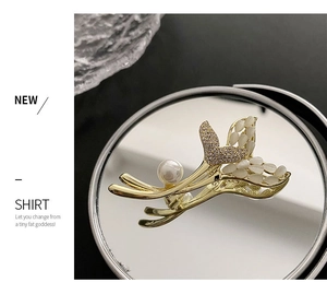 Détail de la broche en queue de poisson avec opale et perle sur support miroir