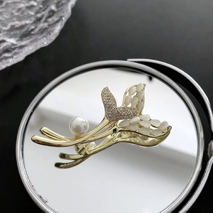 Broche queue de poisson dorée élégante avec pierre œil de chat et perle sur miroir